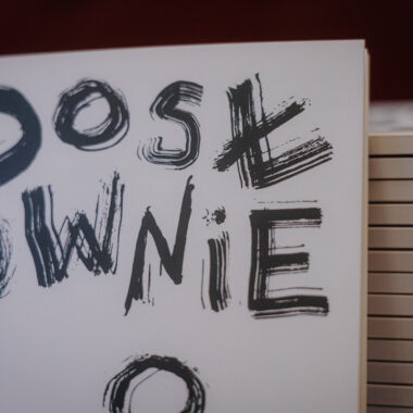 Zbliżenie na kilka egzemplarzy nowej książki Wydawnictwa Dosłownego. Jeden z egzemplarzy stoi oparty o pozostałe, ułożone jeden na drugim.