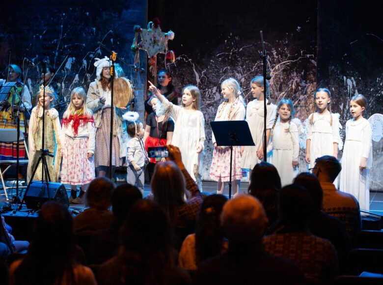 Na scenie grupa śpiewających dzieci, odgrywających jasełka.