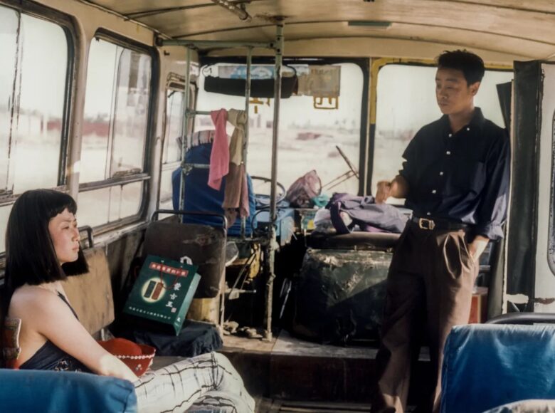 Wnętrze zdezelowanego autobusu. Za kierownicą puste miejsce bez kierowcy. Za kabiną kierowcy na miejscu dla pasażerów siedzi młoda azjatycka dziewczyna. W drzwiach stoi młody azjatycki mężczyzna i patrzy na dziewczynę. Dziewczyna patrzy w dal.