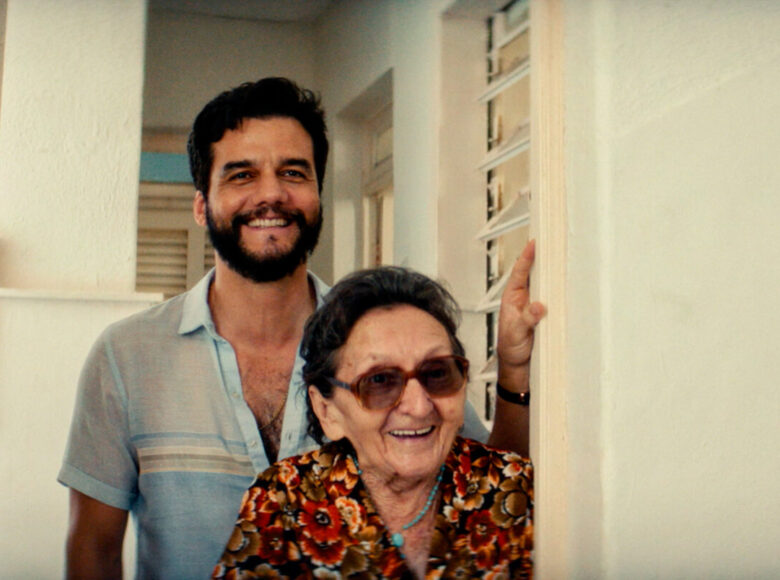 W drzwiach mieszkania stoją dwie uśmiechnięte osoby - stara kobieta i młody mężczyzna.