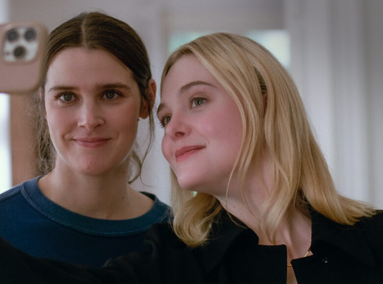 Zbliżenie na dwie dziewczyny, które toją obok siebie i robią sobie wspólne zdjęcie telefonem komórkowym.