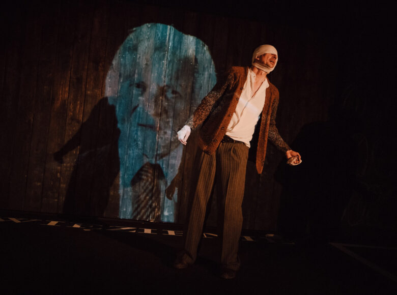 Przedstawienie teatralne. Na scenie stoi mężczyzna.