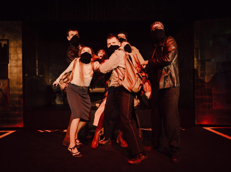 Przedstawienie teatralne. Na scenie grupa aktorów.