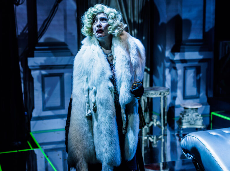Przedstawienie teatralne. Na scenie stoi stara kobieta w futrze z lisa.