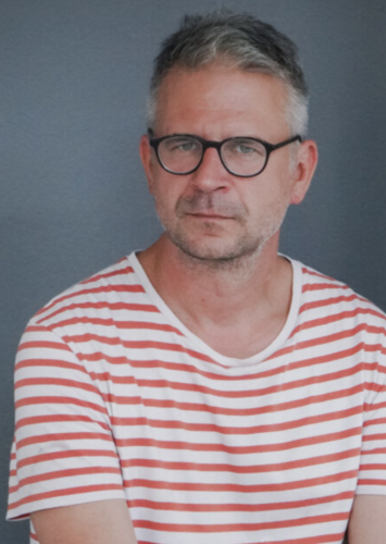 Portret fotograficzny siwego mężczyzny.