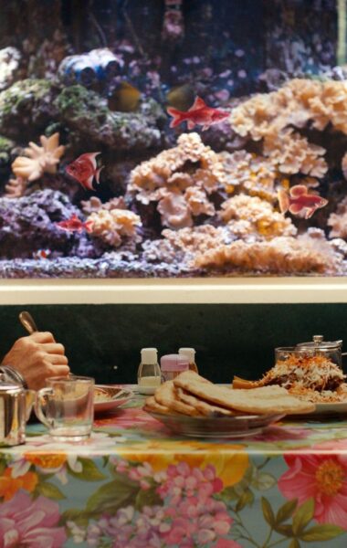 W restauracji przy stoliku siedzą naprzeciwko siebie kobieta i mężczyzna, jedząc jakąś azjatycką potrawę.
