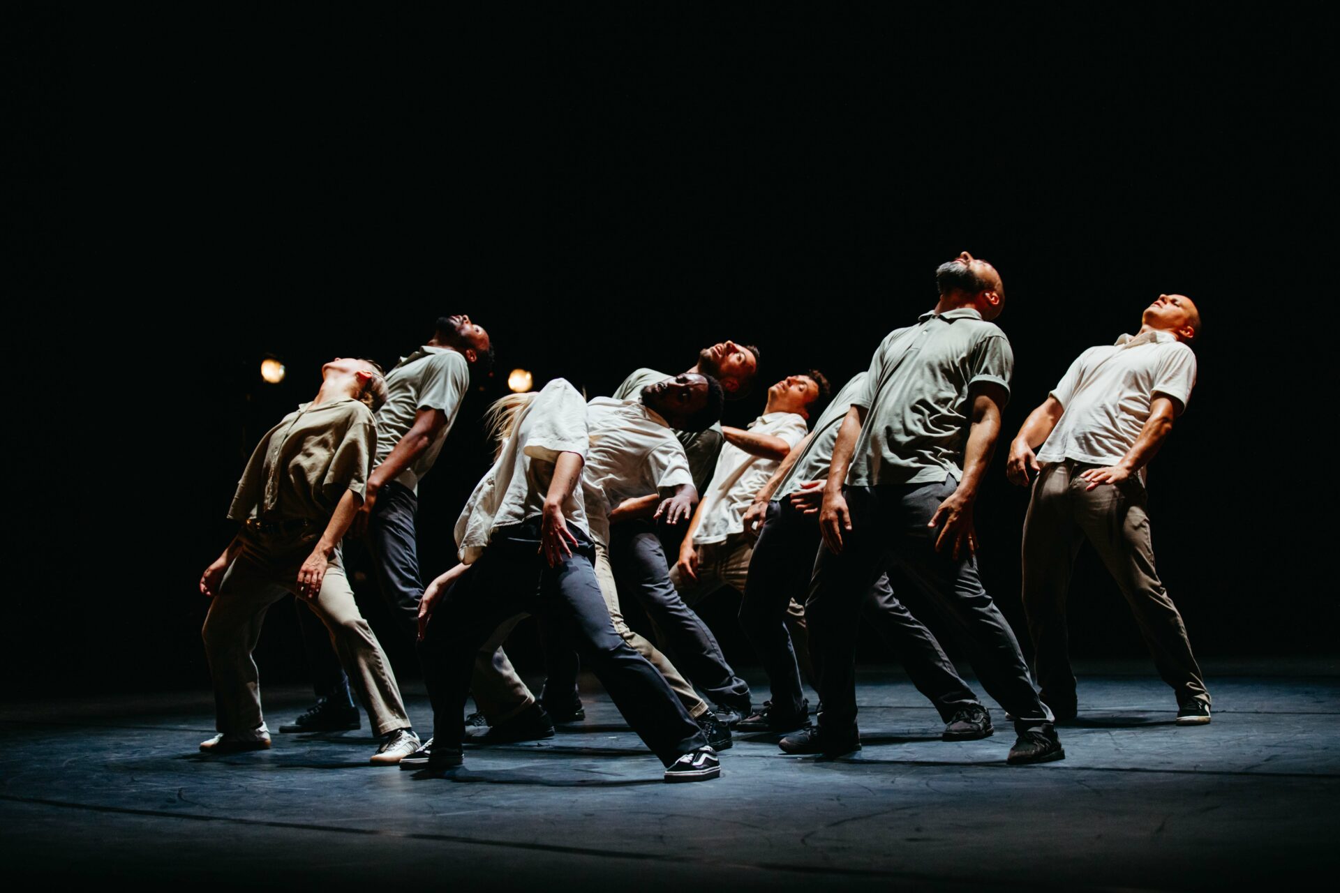Spektakl teatru tańca. Na scenie grupa osób w dynamicznym układzie tanecznym.