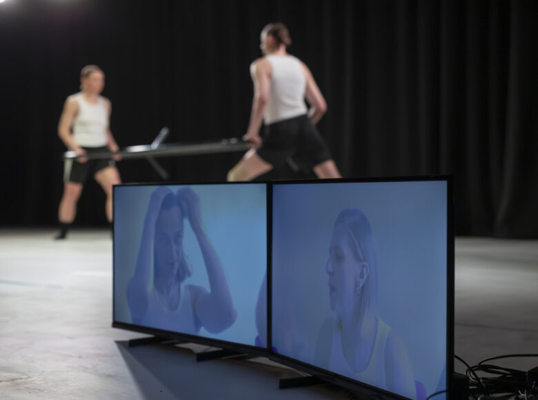 Na scenie tancerka i tancerz tańca współczesnego w układzie choreograficznym.