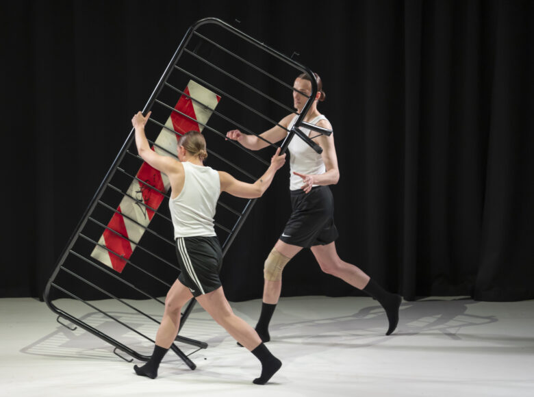 Na scenie tancerka i tancerz tańca współczesnego w układzie choreograficznym.