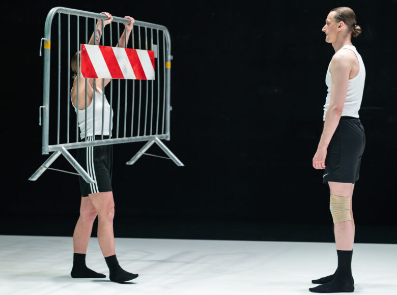Na scenie tancerka i tancerz tańca współczesnego w układzie choreograficznym.