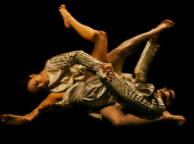 Na scenie dwie tancerki tańca współczesnego w układzie choreograficznym.