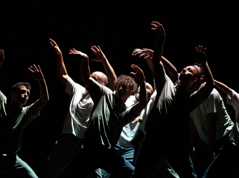 Spektakl teatru tańca. Na scenie grupa osób w dynamicznym układzie tanecznym.