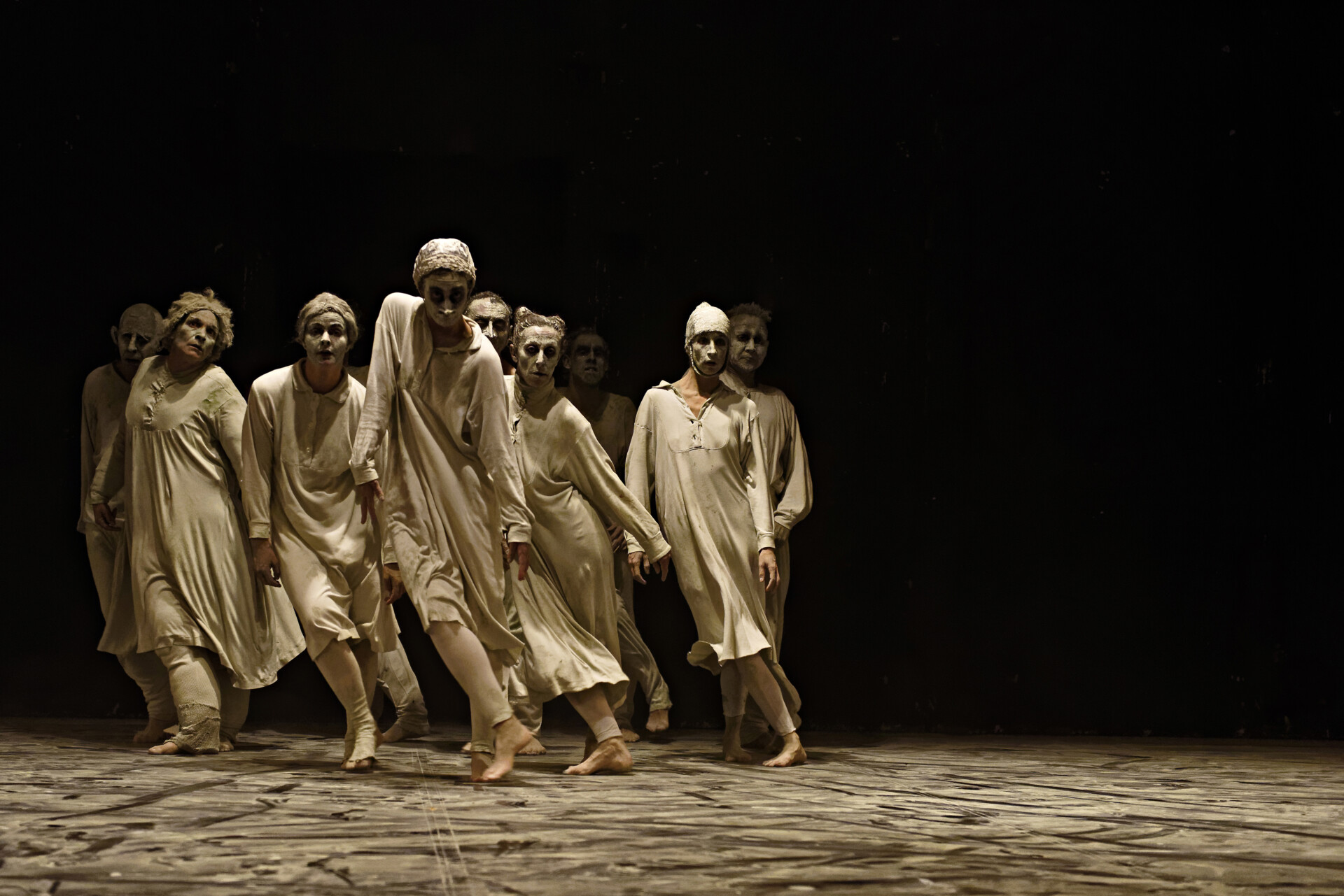 Spektakl teatru tańca. Na scenie grupa osób w dynamicznym układzie tanecznym.