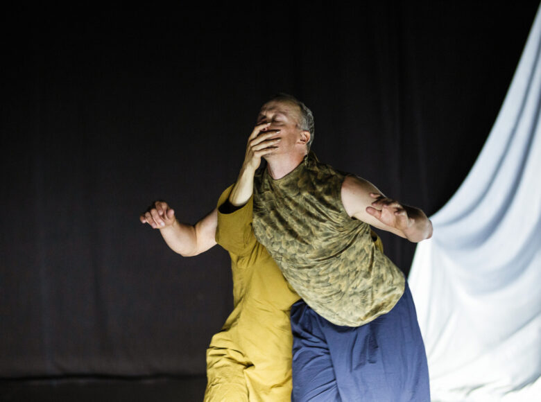 Na scenie tancerka i tancerz tańca współczesnego w układzie choreograficznym.