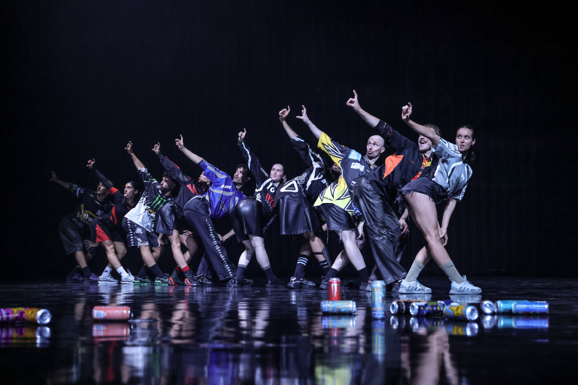 Spektakl teatru tańca. Na scenie grupa osób w dynamicznym układzie tanecznym.