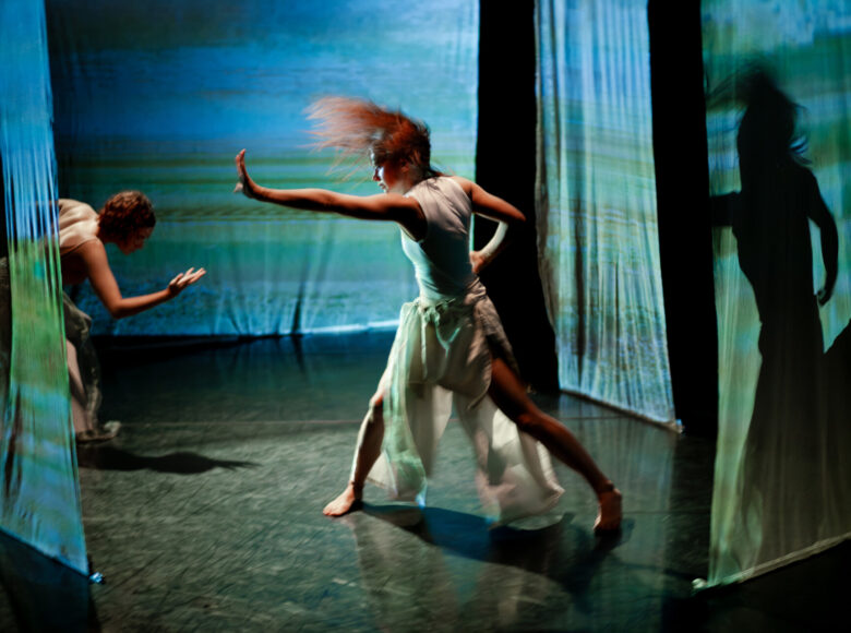 Na scenie dwie tancerki tańca współczesnego w układzie choreograficznym.