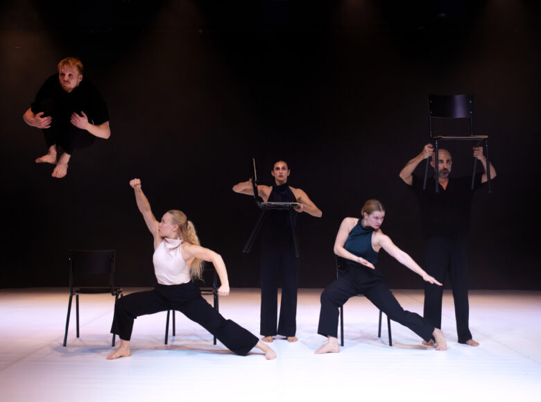 Na scenie grupa tancerek i tancerzy tańca współczesnego w układzie choreograficznym.